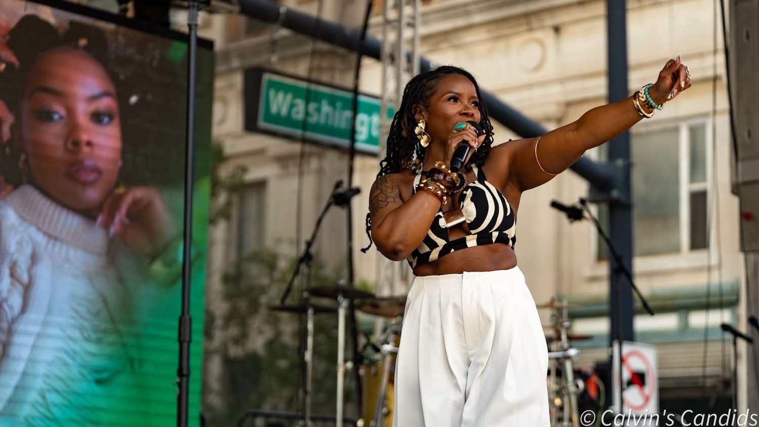 Monique Blanks speaking onstage at an outdoor event